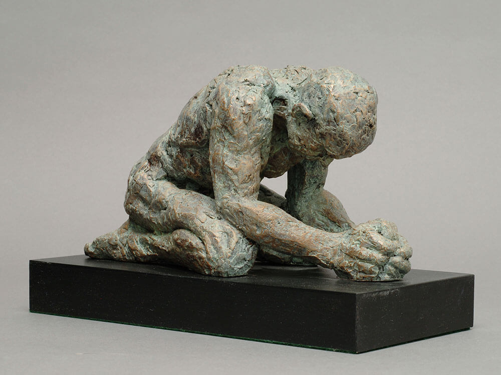 Kneeling and supplicating male figure in cast resin by William Casper.